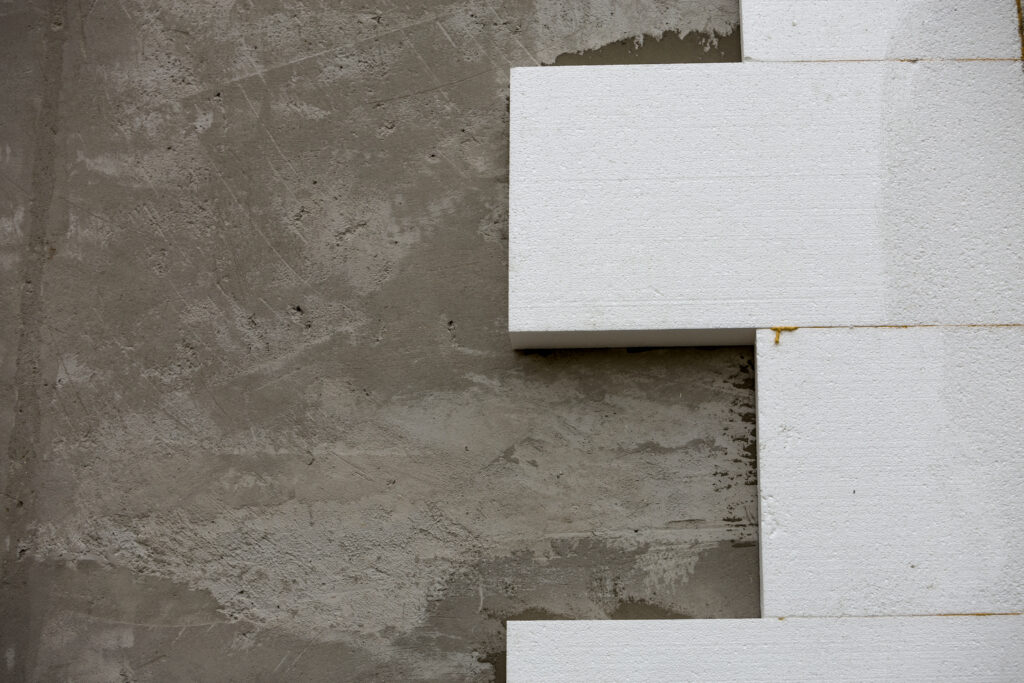 Close-up detail of plastered house wall with rigid styrofoam insulation. Modern technology, construction, renovation, energy saving, alternative for mineral wool, warm comfortable house concept.